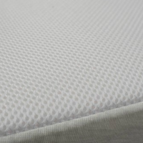 Pormenor do tecido branco em rede da capa da almofada anti-refluxo