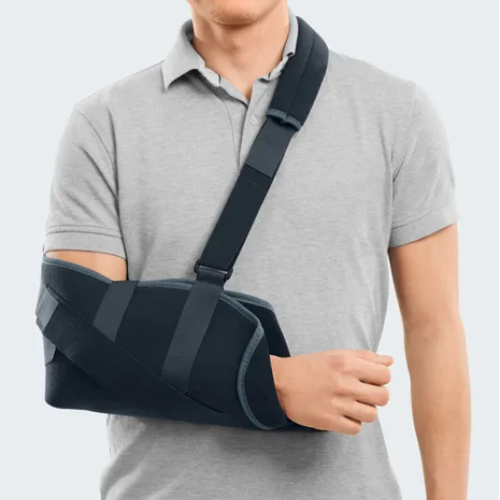Ortótese Arm Sling preta a imobilizar o braço de um homem, com alça a passar pelo ombro