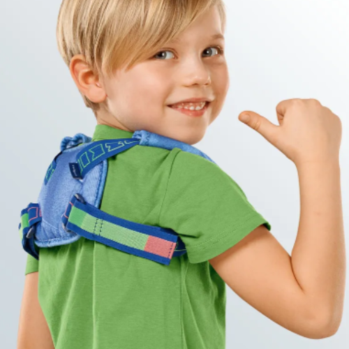 Menino de camisola verde com o suporte de clavícula azul colocado sobre os ombros