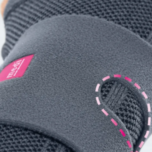 Pormenor da faixa de fecho cinzenta com etiqueta medi cor-de-rosa